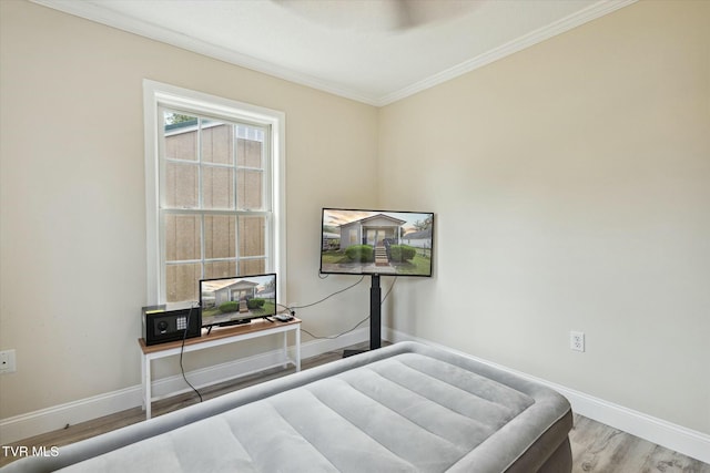 bedroom with ornamental molding and light hardwood / wood-style floors