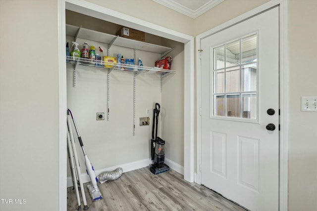 washroom with hookup for a washing machine, crown molding, hookup for an electric dryer, and light wood-type flooring