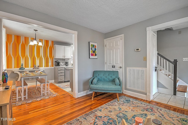 sitting room featuring a chandelier, a textured ceiling, and light hardwood / wood-style floors