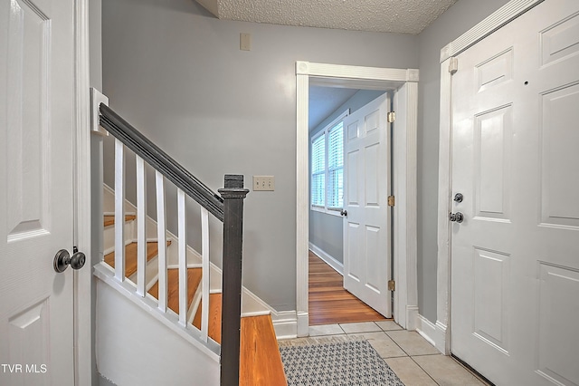 tiled entrance foyer featuring a textured ceiling