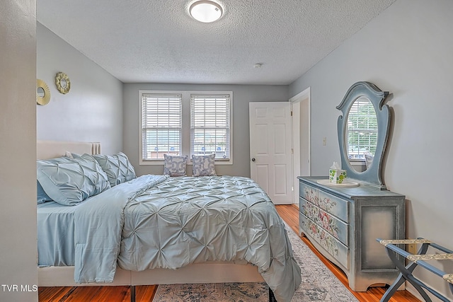 bedroom featuring hardwood / wood-style floors and a textured ceiling