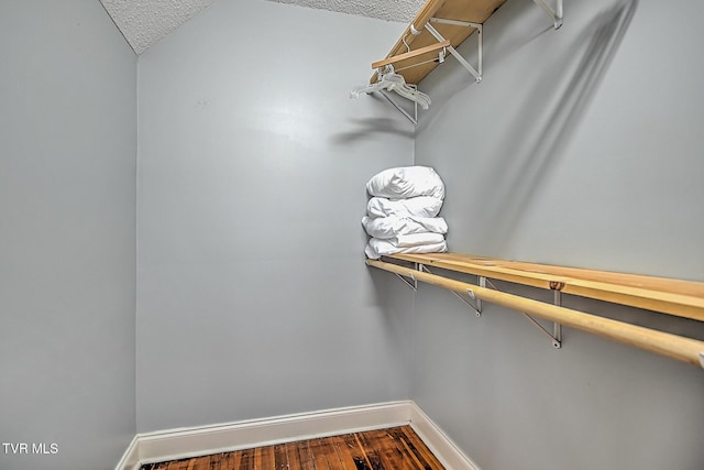 spacious closet with hardwood / wood-style flooring and vaulted ceiling