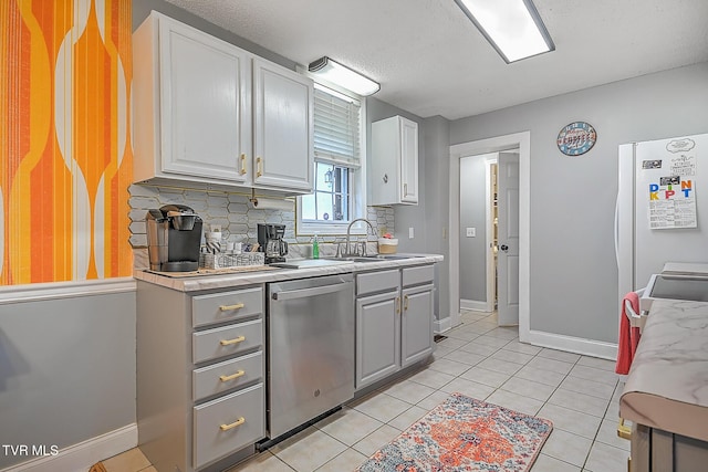 kitchen featuring dishwasher, white cabinetry, backsplash, light tile patterned flooring, and white fridge