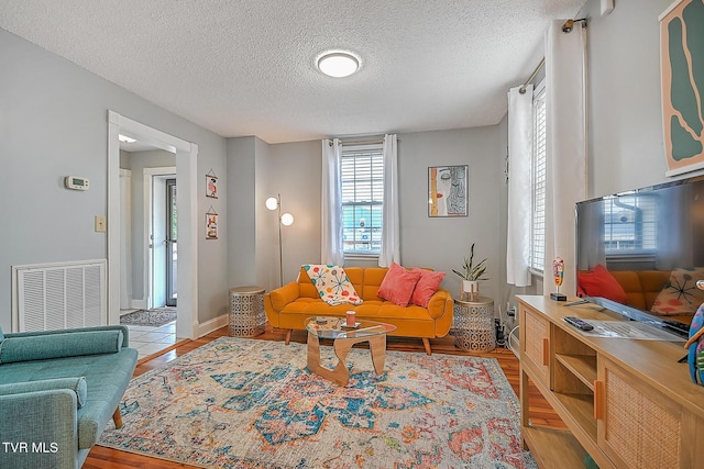 living room featuring a textured ceiling and light hardwood / wood-style floors