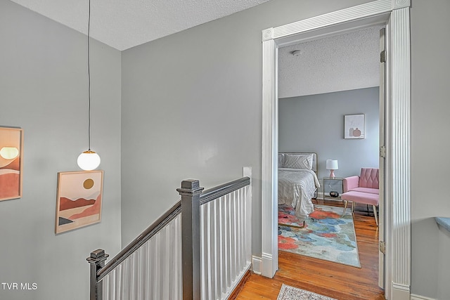 hallway featuring a textured ceiling and light hardwood / wood-style flooring