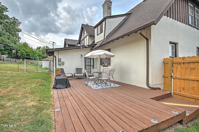 wooden terrace featuring a yard