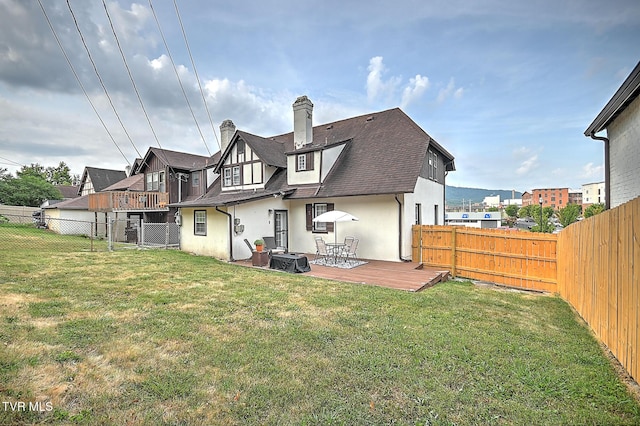 back of property with a wooden deck and a yard