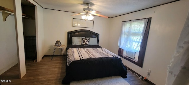 bedroom with crown molding, a textured ceiling, dark wood-type flooring, and ceiling fan