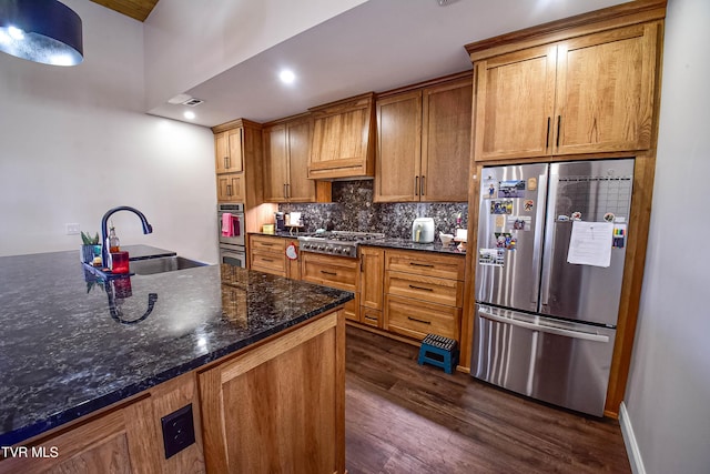 kitchen with dark wood-type flooring, sink, dark stone countertops, appliances with stainless steel finishes, and custom range hood