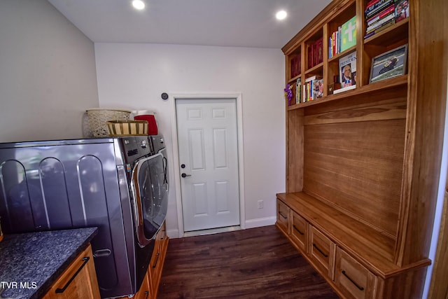 clothes washing area with washing machine and clothes dryer and dark hardwood / wood-style flooring