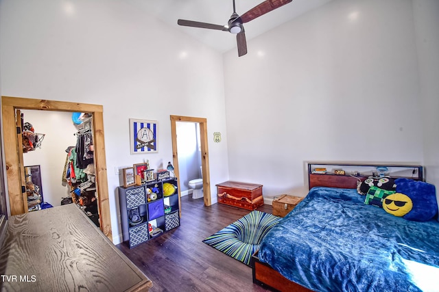 bedroom featuring dark wood-type flooring, connected bathroom, high vaulted ceiling, a closet, and ceiling fan