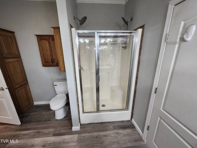 bathroom with walk in shower, toilet, and hardwood / wood-style flooring