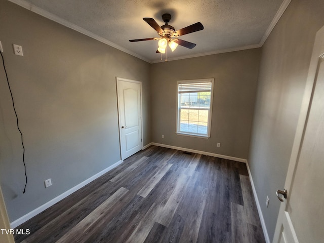 empty room with ornamental molding, ceiling fan, a textured ceiling, and dark hardwood / wood-style flooring