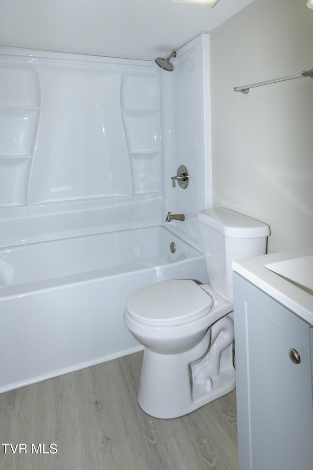 full bathroom with vanity, hardwood / wood-style floors, toilet, and washtub / shower combination