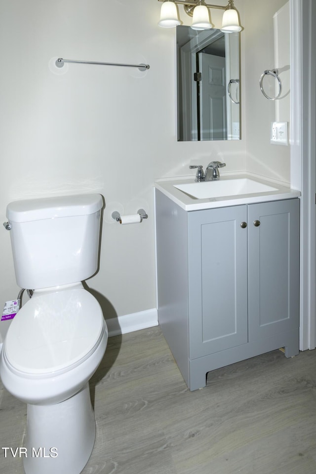 bathroom featuring vanity, hardwood / wood-style floors, and toilet