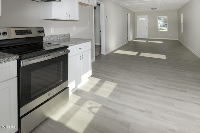 kitchen featuring white cabinetry, stainless steel electric stove, light stone countertops, and light wood-type flooring