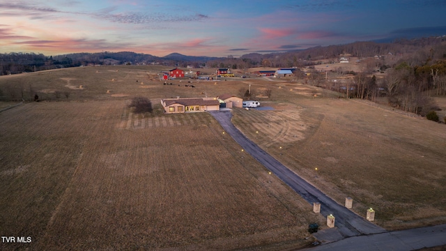 aerial view at dusk with a rural view and a mountain view