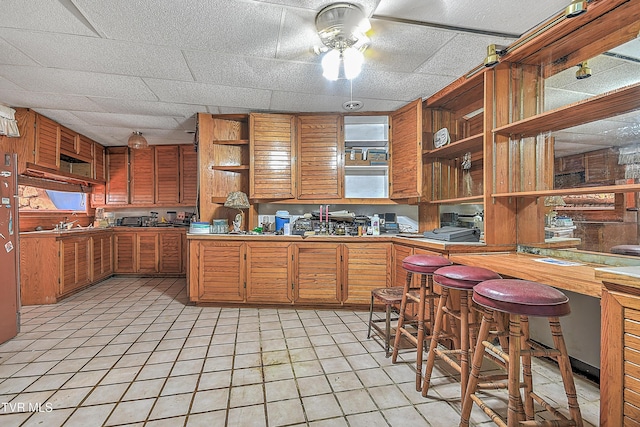 169 Church Cir, Bristol, TN 37620 - kitchen featuring open shelves, a ceiling fan, brown cabinetry, and light tile patterned flooring