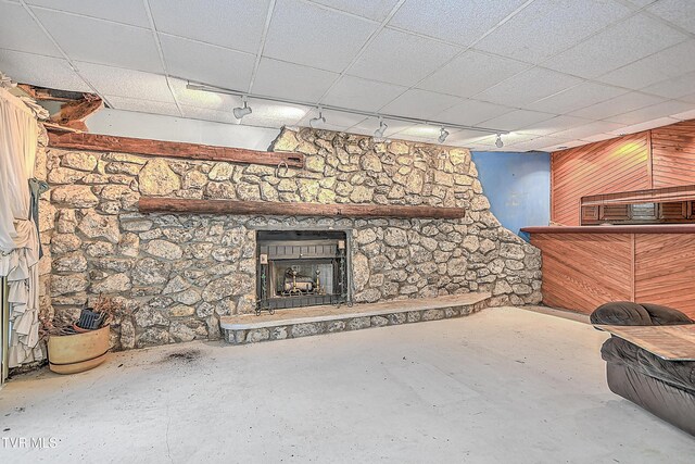 169 Church Cir, Bristol, TN 37620 - unfurnished living room featuring a fireplace, rail lighting, wood walls, and concrete flooring