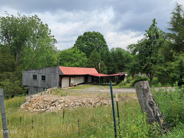 169 Church Cir, Bristol, TN 37620 - back of house with driveway, a garage, a pole building, an outdoor structure, and metal roof