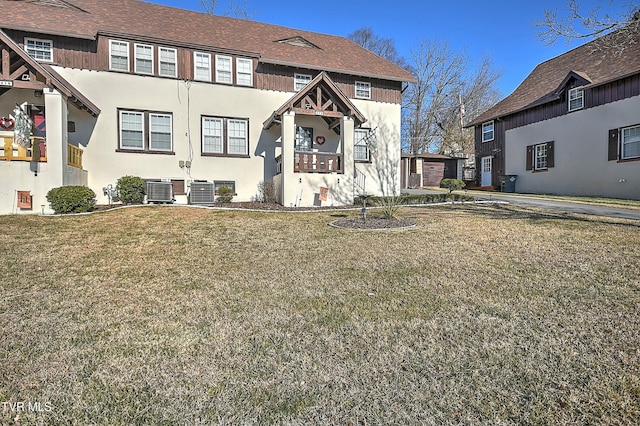 view of front of house with central AC unit and a front lawn