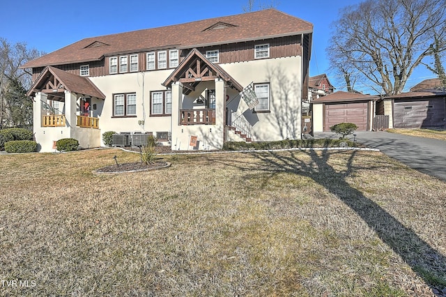 view of front of property with central AC unit, a garage, an outdoor structure, and a front lawn