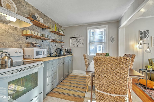 kitchen featuring white appliances, ornamental molding, gray cabinets, and sink