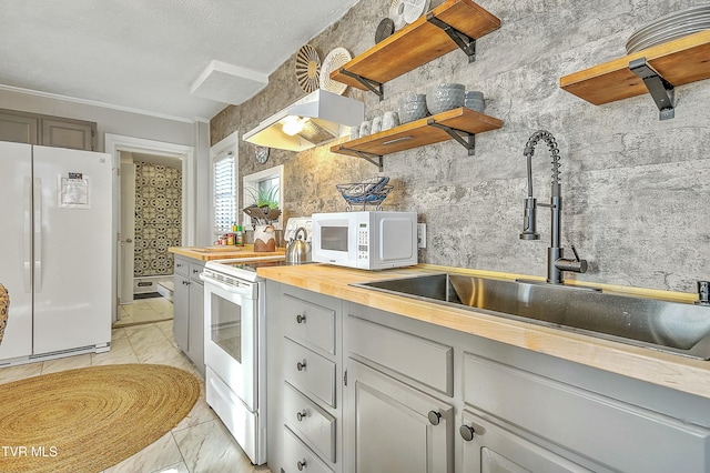 kitchen featuring wood counters, sink, and white appliances