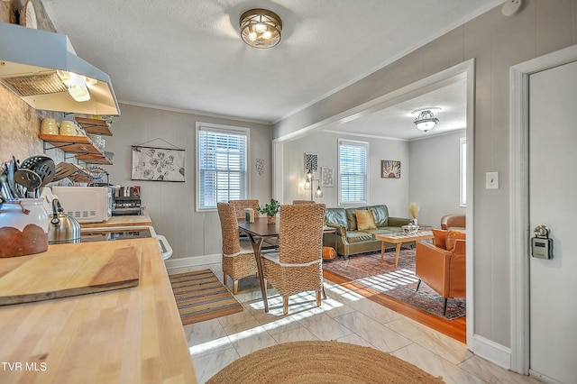 dining space with ornamental molding and a textured ceiling