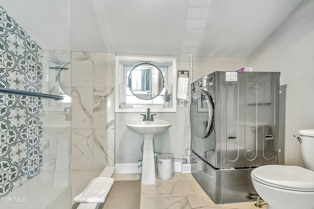 bathroom with a tile shower and toilet