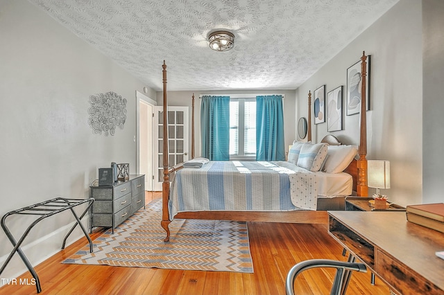 bedroom with light hardwood / wood-style flooring and a textured ceiling