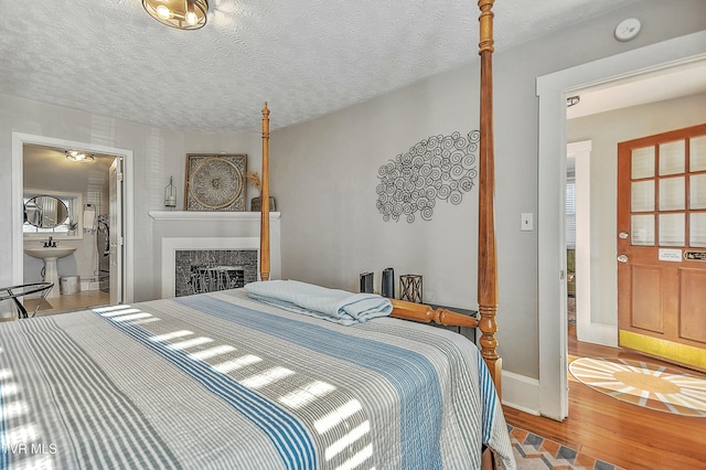 bedroom with hardwood / wood-style flooring, sink, and a textured ceiling