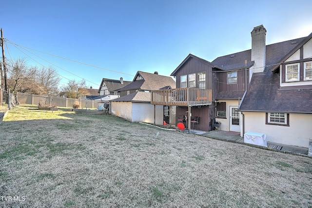 rear view of house with a lawn and a deck