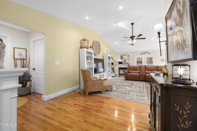 living room with lofted ceiling, a fireplace, light hardwood / wood-style flooring, and ceiling fan