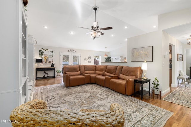 living room with wood-type flooring, vaulted ceiling, and ceiling fan