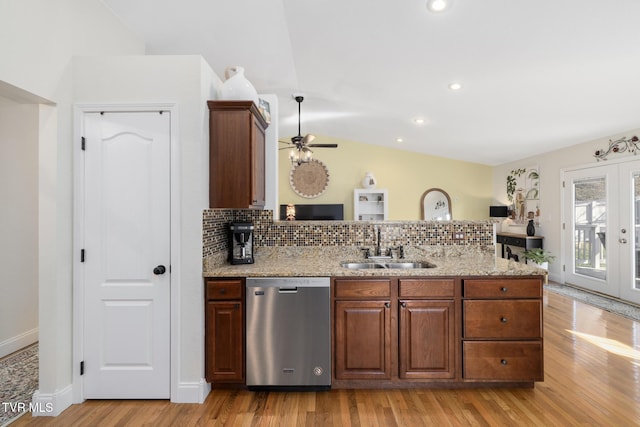 kitchen with tasteful backsplash, dishwasher, sink, light wood-type flooring, and french doors