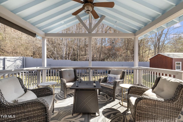 wooden deck featuring an outdoor hangout area, ceiling fan, and a storage shed