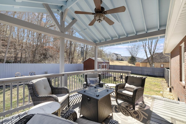 wooden terrace featuring a lawn and a storage shed