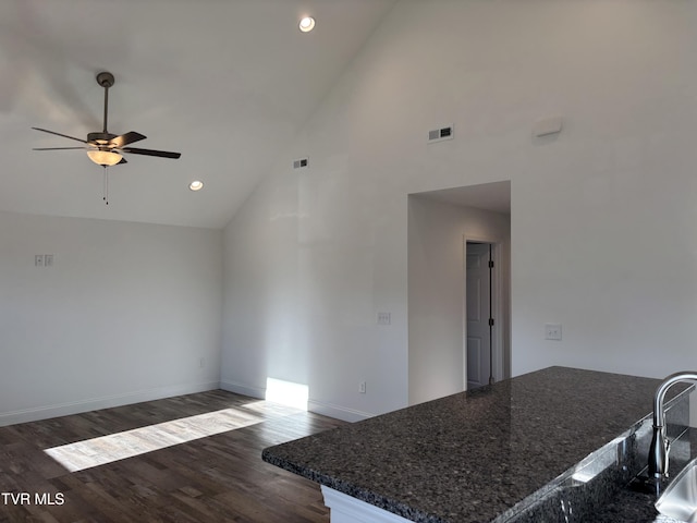 interior space featuring ceiling fan, dark wood-type flooring, and high vaulted ceiling