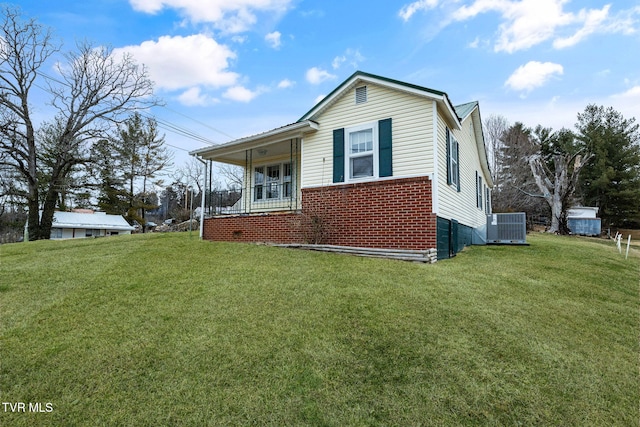 view of front facade with central air condition unit, covered porch, and a front lawn