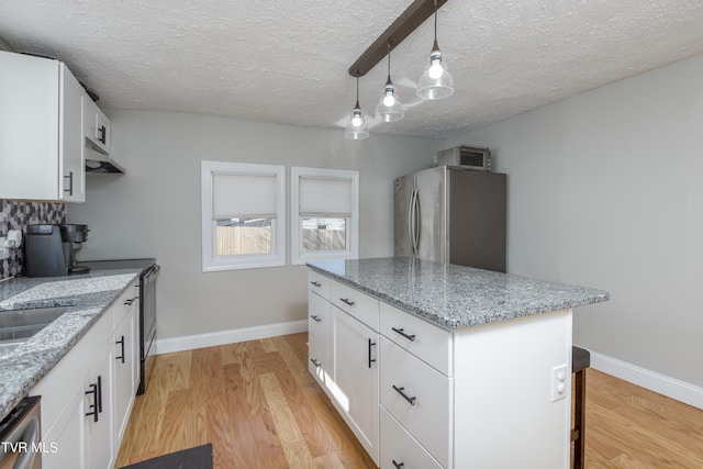 kitchen featuring hanging light fixtures, appliances with stainless steel finishes, a center island, and white cabinets