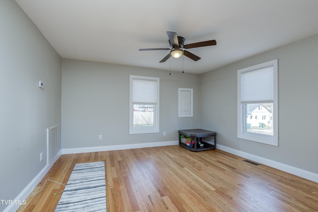 empty room featuring ceiling fan, light hardwood / wood-style flooring, and a healthy amount of sunlight