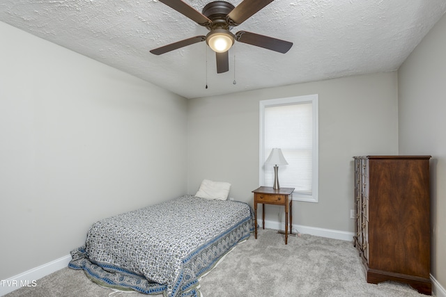 carpeted bedroom with ceiling fan and a textured ceiling