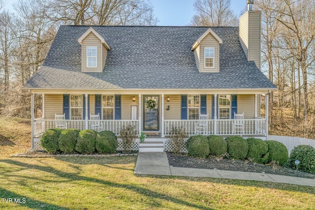 new england style home featuring covered porch and a front yard