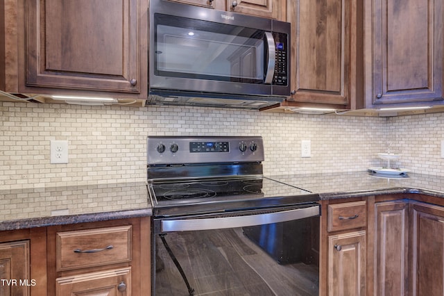 kitchen with dark stone countertops, decorative backsplash, and stainless steel electric stove