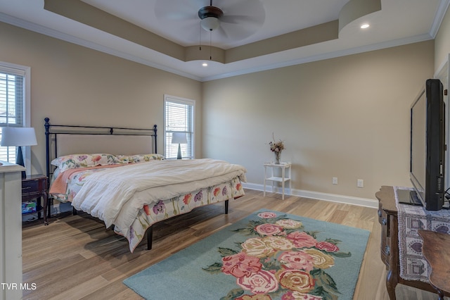 bedroom featuring a raised ceiling, wood-type flooring, ornamental molding, and ceiling fan