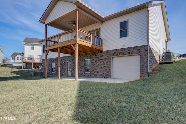 back of property featuring a garage, a lawn, ceiling fan, and a patio area