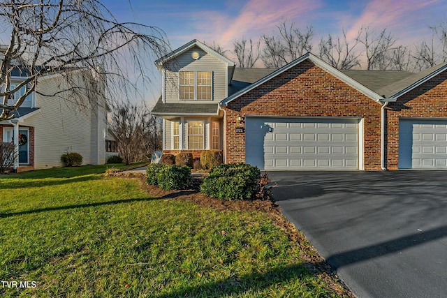 front facade featuring a garage and a yard