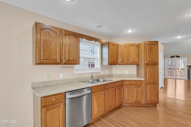 kitchen featuring sink, a textured ceiling, light hardwood / wood-style flooring, and dishwasher