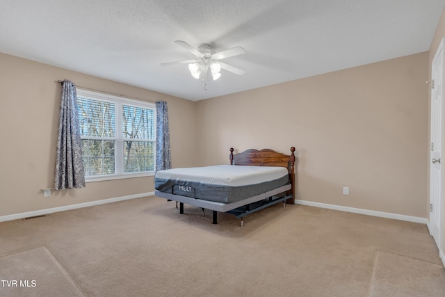 bedroom with light carpet, a textured ceiling, and ceiling fan